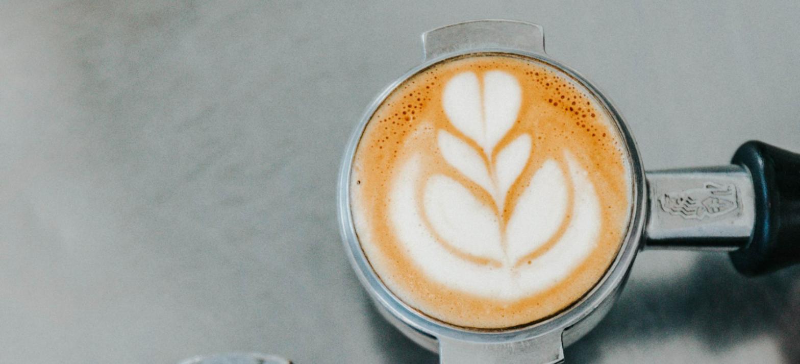Café com leite com desenho de folha na espuma