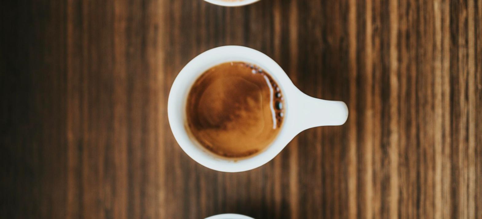 Xícara branca de cerâmica com café, vista de cima